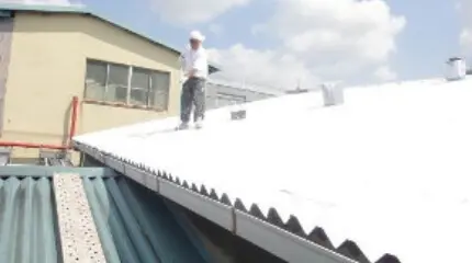 暑さ対策・省エネ対策になる遮熱塗料ミラクールを工場・倉庫・店舗の屋根に塗装している様子
